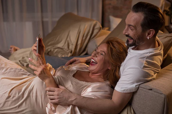 Joyeux couple marié riant à la vidéo sur gadget — Photo