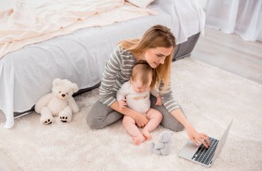 Happy mom with child on carpet clipart