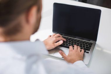 Laptop önünde oturan genç işadamı