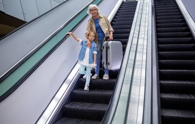 Neşeli yaşlı kadın ve çocuk merdiven üzerinde hareket ediyor