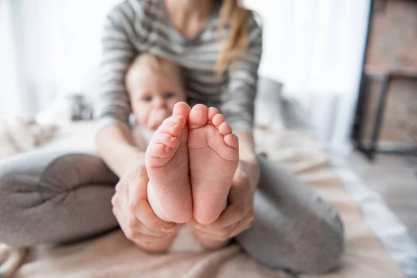 Proud mother displaying cute feet of her child — Stock Photo, Image