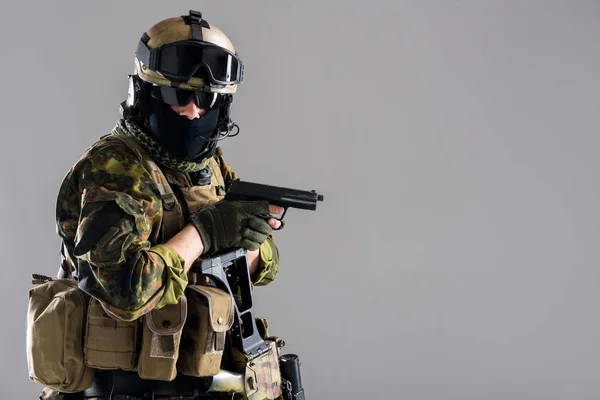 Seriöser Soldat hält Pistole in der Waffe — Stockfoto