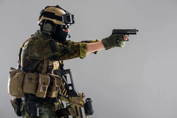 Schwerer Mann in Militäruniform mit Waffe — Stockfoto