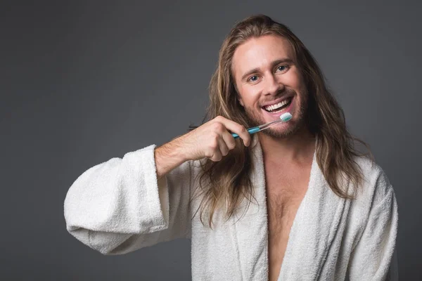 Joven alegre sosteniendo cepillo de dientes — Foto de Stock