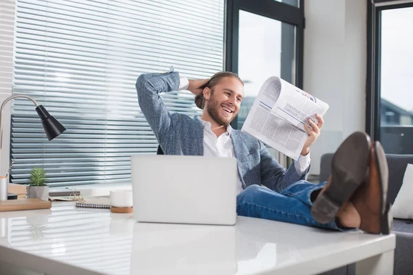 Amused man looking at journal with joy — Stock Photo, Image