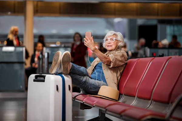 Пожилая женщина наслаждается онлайн-разговором на мобильном телефоне — стоковое фото