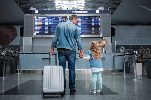 Homem alegre está de pé com a criança no aeroporto — Fotografia de Stock