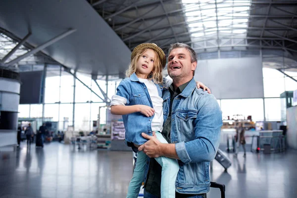 Se pregunta hombre de mediana edad está de pie con el niño en el terminal moderno —  Fotos de Stock