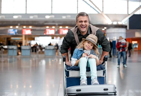 Terminalde oynayan neşeli yetişkin adam ve küçük kız — Stok fotoğraf