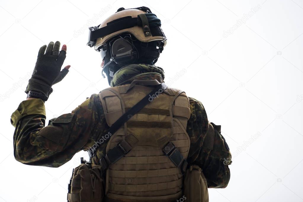 Soldier in ammunition rising hand up