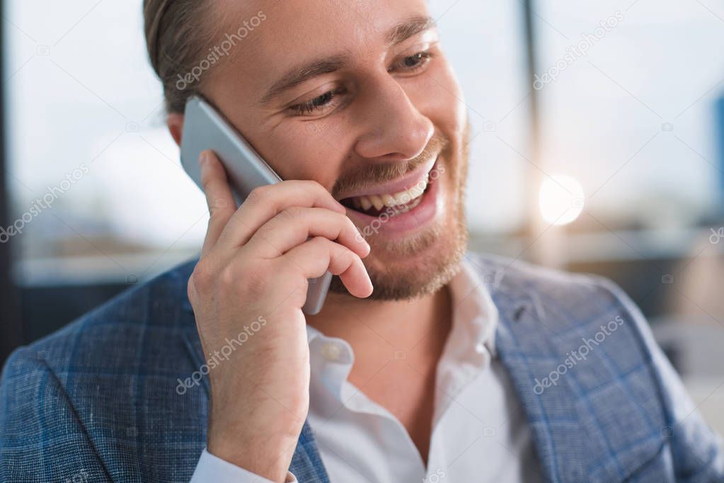 Laughing clerk communicating on cellphone
