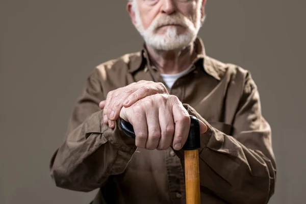 Небритый пенсионер-инвалид с деревянной палкой — стоковое фото