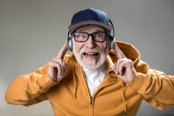 Pensionista moderno escuchando música desde auriculares — Foto de Stock