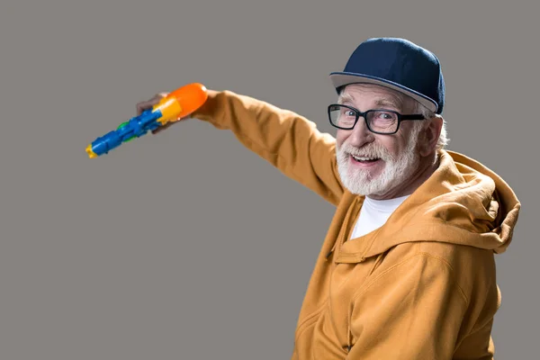 Contented pensioner having fun with toy — Stock Photo, Image