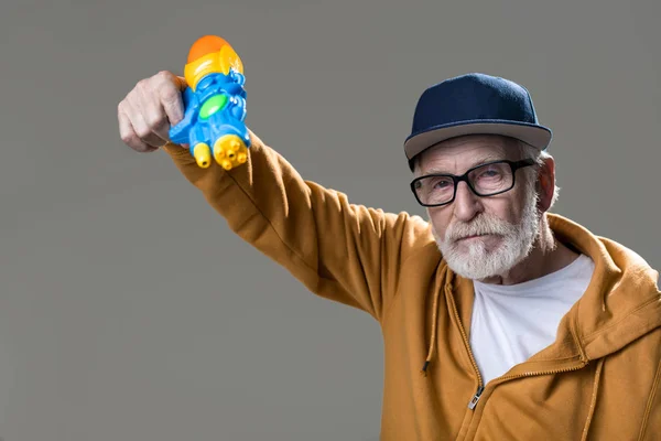 Прохолодний старий тримає сквірт пістолет — стокове фото