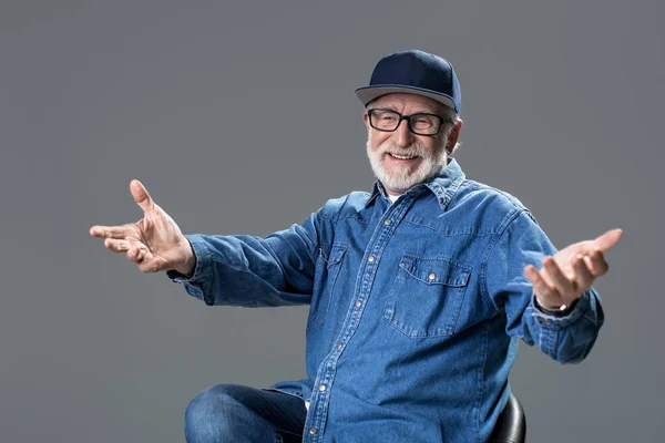 Viejo barbudo sonriente sentado en la silla — Foto de Stock