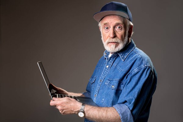 Confused male pensioner with laptop