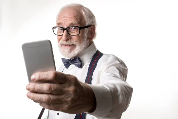 Moderna manlig pensionär tar foto på smartphone — Stockfoto