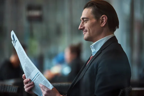 Cheerful man looking through article — Stock Photo, Image