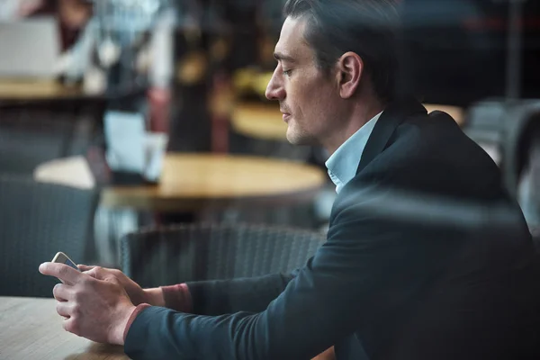 Calm male watching at display of mobile — Stock Photo, Image