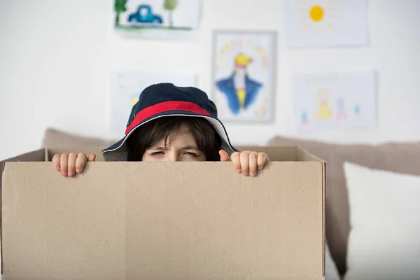 Fearful little boy hiding inside of cardboard box — Stock Photo, Image