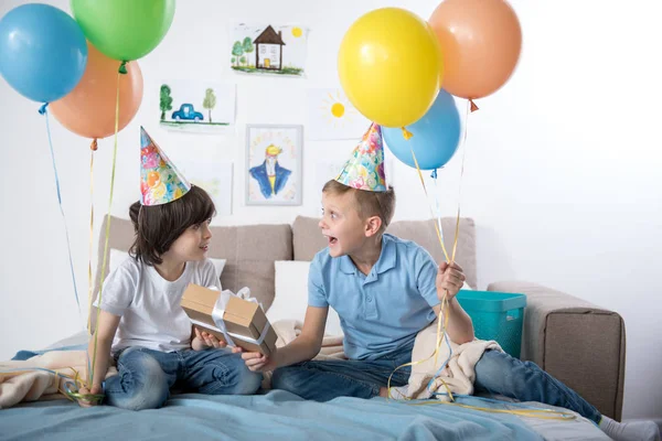 Niños satisfechos disfrutando de la fiesta de cumpleaños en el interior — Foto de Stock