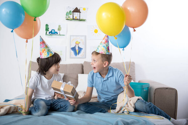 Pleased kids enjoying birthday party indoors