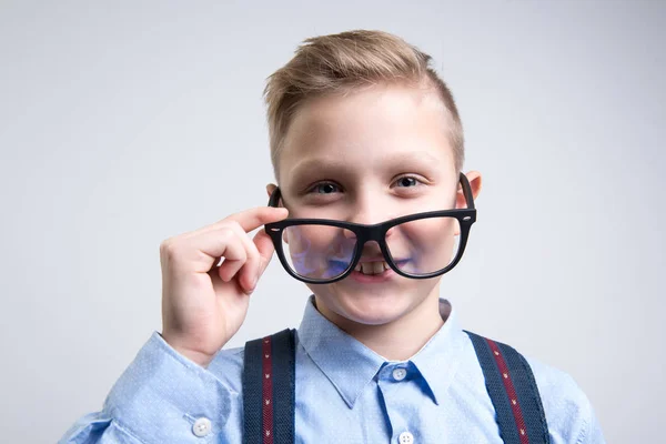 Niño inteligente de la escuela que se pone gafas — Foto de Stock