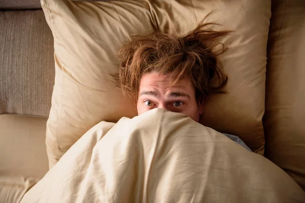 Сонный взрослый мужчина просыпается на работу в спальне — стоковое фото