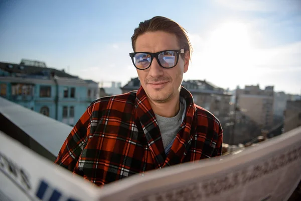 Ragazzo soddisfatto in piedi sul balcone con giornale — Foto Stock