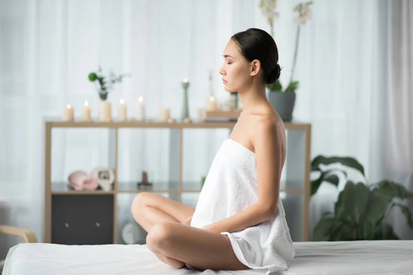 Mujer joven y pacífica meditando en el spa — Foto de Stock