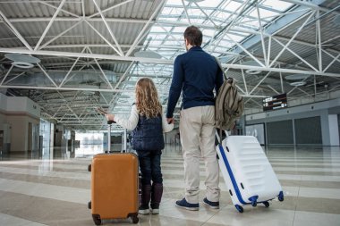 Dad and child standing with baggage clipart