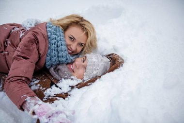 Neşeli genç adam ve kadın kar üzerinde eğleniyor musun