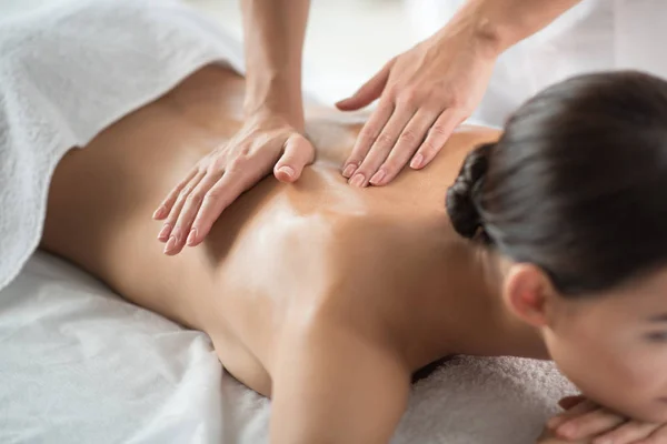 Esteticista habilidoso fazendo massagem para menina relaxada — Fotografia de Stock