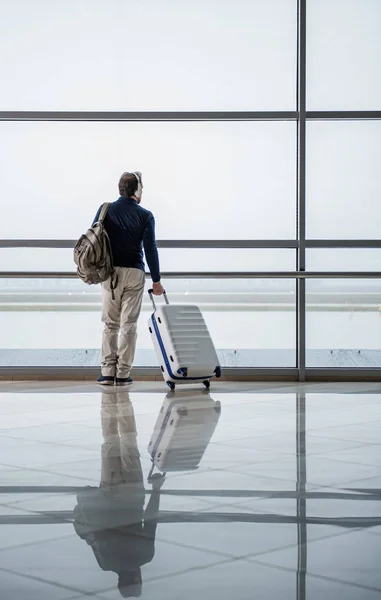 Homem atencioso ouvindo música no aeroporto — Fotografia de Stock