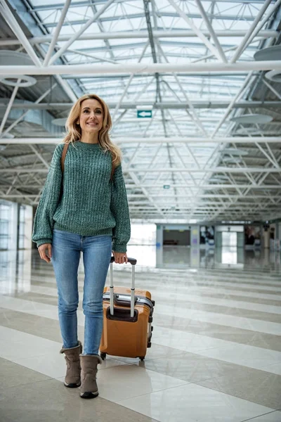 Радостная женщина, идущая по коридору аэропорта — стоковое фото