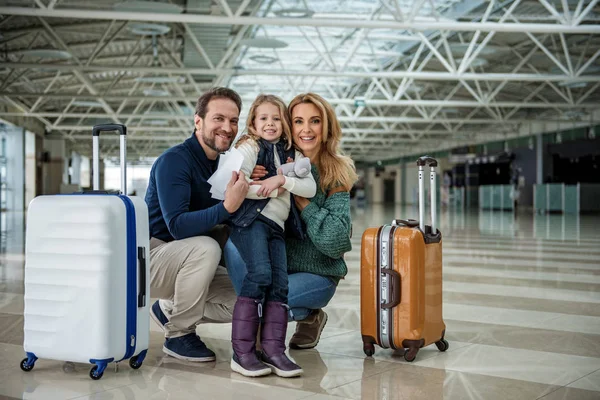 Mosolygó család vár regisztráció a repülőtéren — Stock Fotó