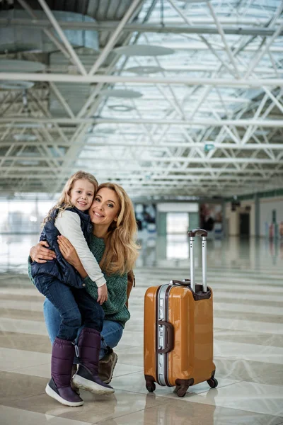 Mujer feliz y su hijo abrazándose antes de abordar — Foto de Stock