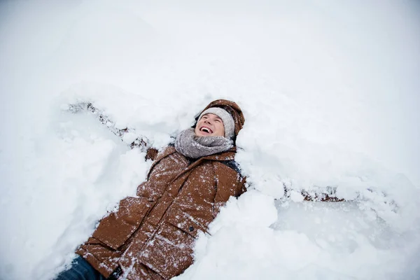 Joyful guy relaxing on snow