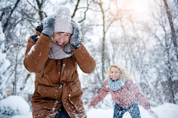 Веселая пара, играющая со снегом в зимнем лесу — стоковое фото