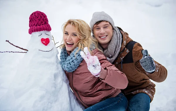 Gioioso giovane uomo e donna che si diverte con la neve in inverno — Foto Stock