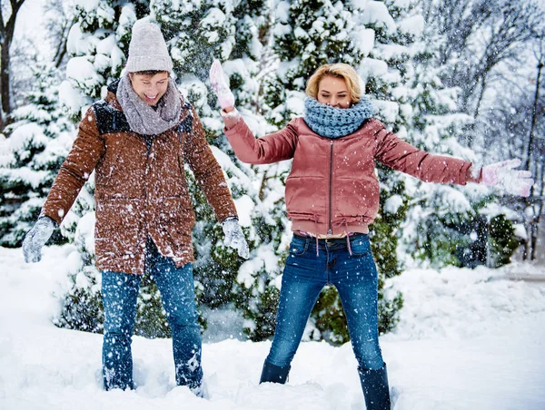 Sorglösa vänner att spela med snö i skogen — Stockfoto