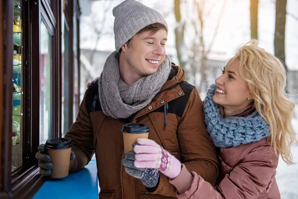 Cheerful guy treating his girlfriend with hot beverage — Stock Photo, Image