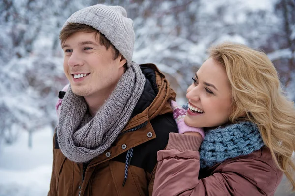 Sorglös ung man och kvinna som spelar i snöiga väder — Stockfoto