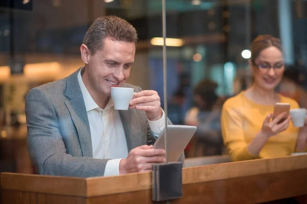 Uomo felice guardando gadget in caffè — Foto Stock