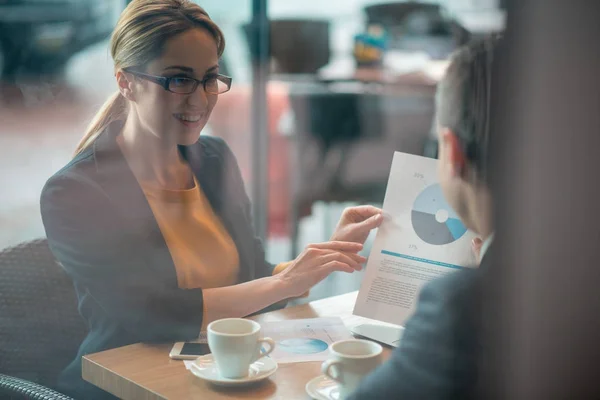 Outgoing lady showing statistics to partner — Stock Photo, Image