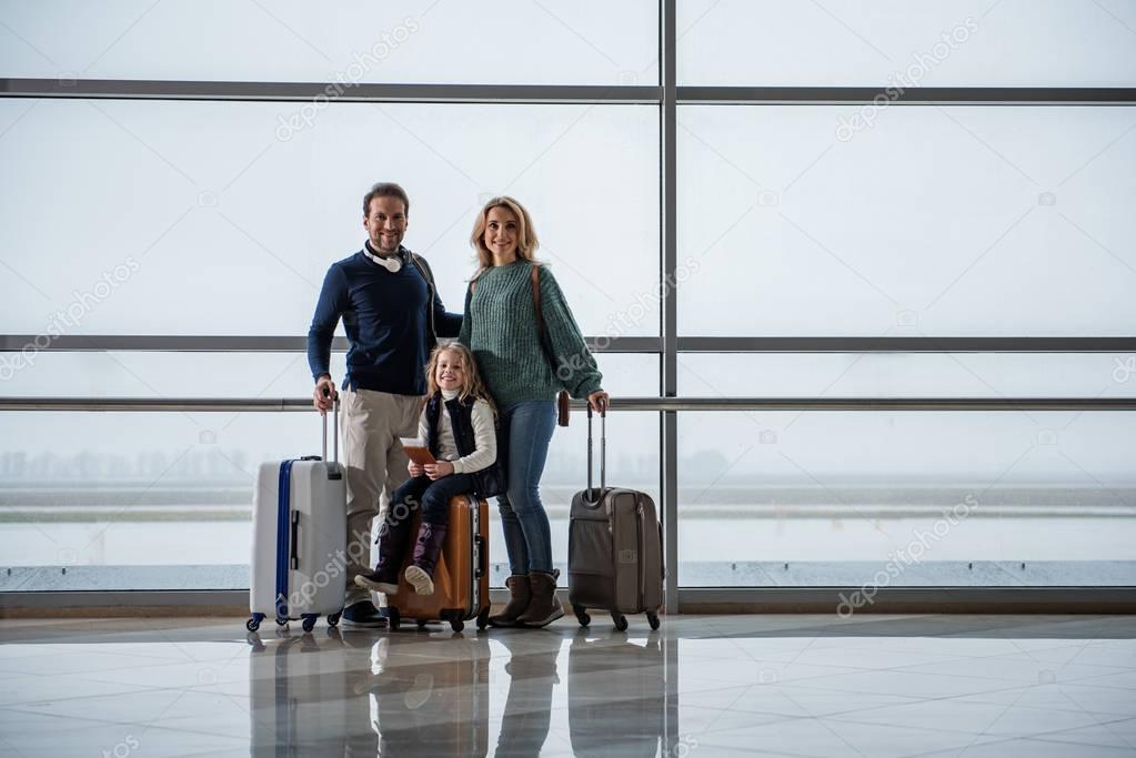 Happy family standing near runway