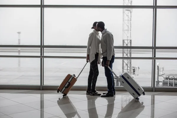 Homme et femme avec bagages se réunissent au salon du terminal — Photo