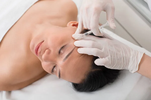 Mujer madura feliz tomando una inyección en el spa — Foto de Stock