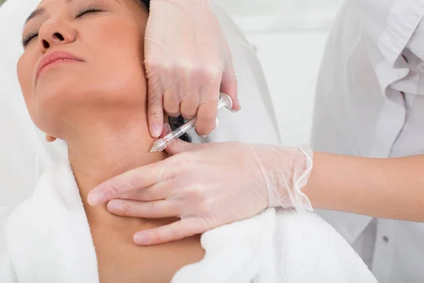 Mujer asiática tensa tomando una inyección en el spa — Foto de Stock